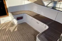 2007 Comar Comet 62 RS yacht deck with wooden seating and storage compartments.