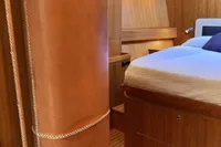 Luxurious interior of 2007 Comar Comet 62 RS yacht with wooden finishes and cozy bed.