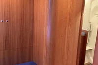 Interior of 2007 Comar Comet 62 RS yacht with wooden paneling and blue cushioned seating.