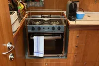 2007 Comar Comet 62 RS yacht kitchen with stove and wooden cabinetry.