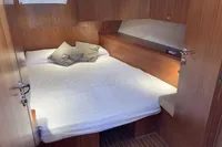 Cozy cabin interior of 2007 Comar Comet 62 RS yacht with wooden finish and double bed.