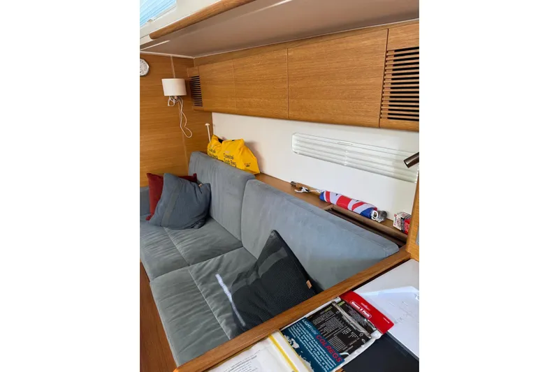 Build No.31 Yacht Photos Pics Interior of 2021 X-Yachts 4.6, featuring a cozy sofa and wooden cabinetry.