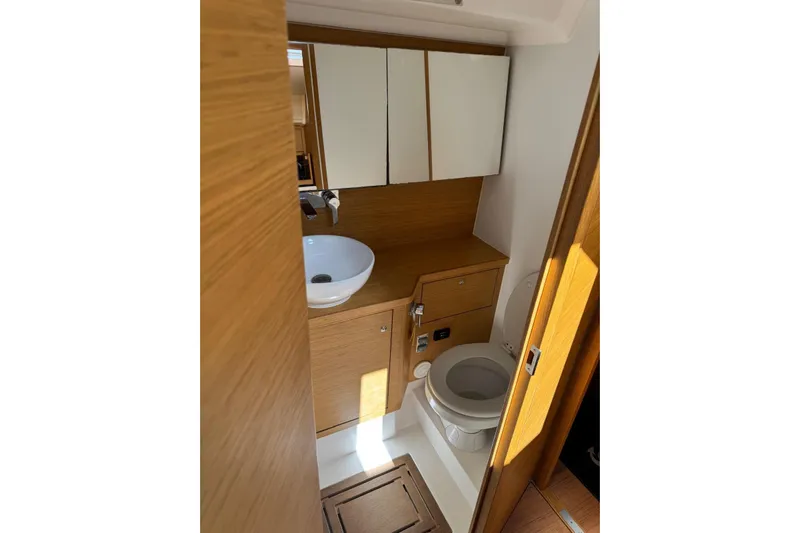 Build No.31 Yacht Photos Pics Modern yacht bathroom with wooden cabinetry, sink, and toilet in 2021 X-Yachts 4.6 model.