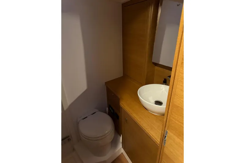 Build No.31 Yacht Photos Pics Modern yacht bathroom with wooden cabinetry, vessel sink, and toilet in 2021 X-Yachts 4.6 model.