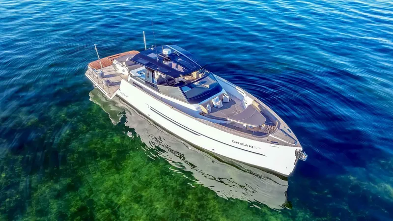  Yacht Photos Pics Luxury 2025 OKEAN 57 yacht cruising on clear blue water.
