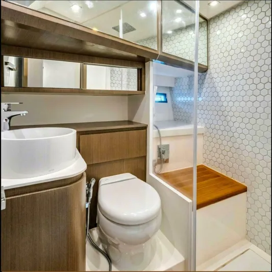  Yacht Photos Pics Modern bathroom in 2025 OKEAN 57 yacht with wood accents and hexagonal tiles.