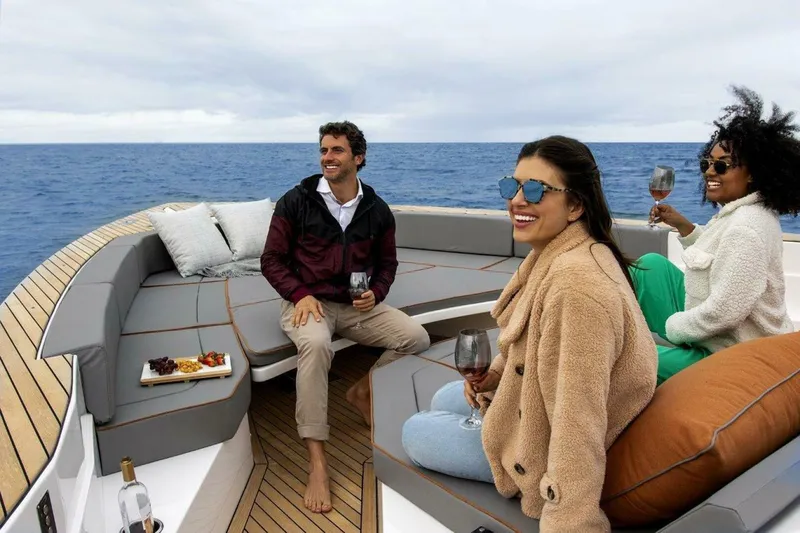  Yacht Photos Pics Three people enjoying wine on a luxurious 2025 OKEAN 57 yacht at sea.