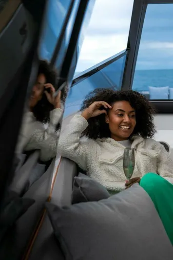  Yacht Photos Pics Woman relaxing on a 2025 OKEAN 57 yacht, holding a drink, with ocean view.