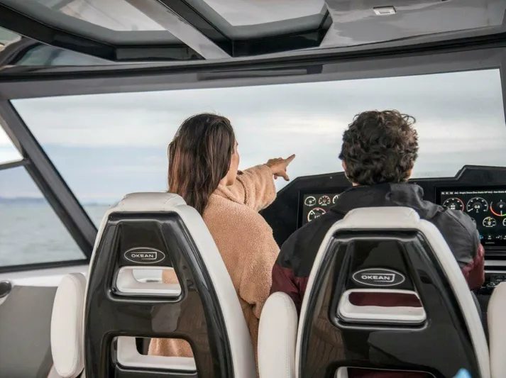  Yacht Photos Pics Two people navigating on a 2025 OKEAN 57 yacht, pointing towards the horizon.