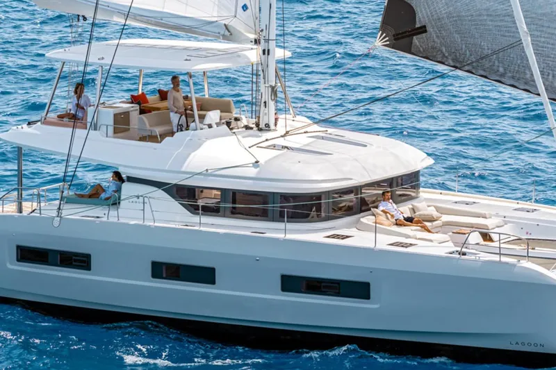  Yacht Photos Pics 2026 Lagoon 55 yacht sailing with passengers on a sunny day.