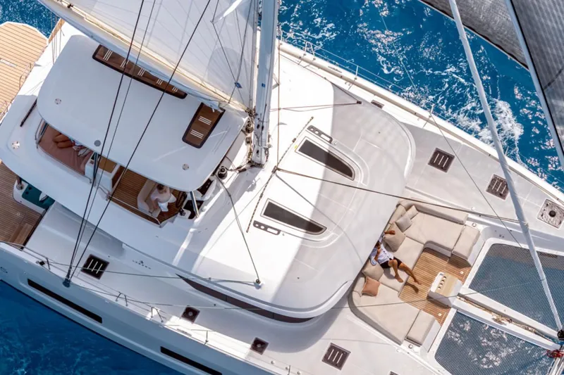  Yacht Photos Pics Aerial view of 2026 Lagoon 55 yacht sailing on clear blue water.