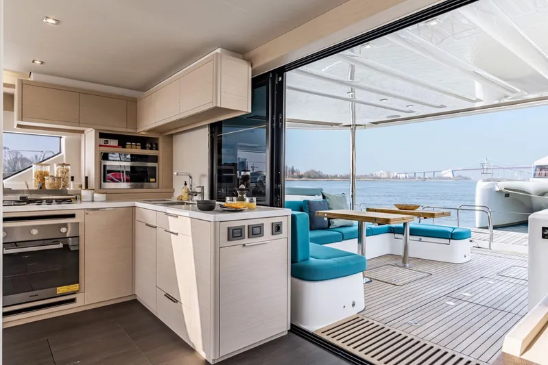  Yacht Photos Pics Modern kitchen and dining area on 2026 Lagoon 55 yacht with scenic water view.