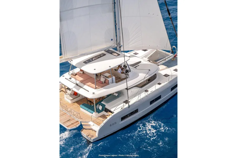  Yacht Photos Pics Luxurious 2026 Lagoon 55 yacht sailing on clear blue ocean waters.