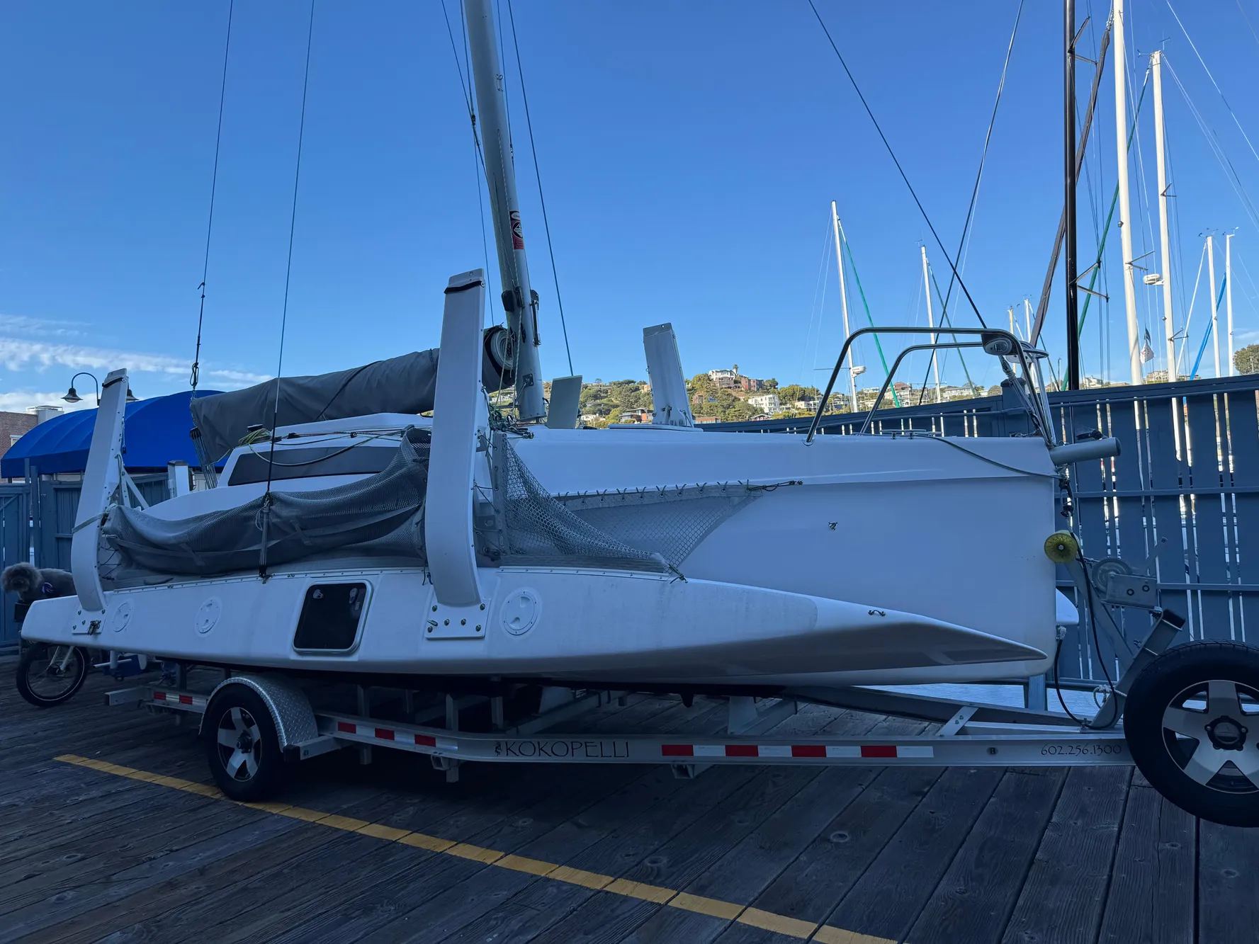 2018 Corsair 760 Sport sailboat on trailer at marina dock.