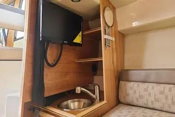  Yacht Photos Pics 2023 Cutwater C-248 Coupe interior with TV, sink, and seating area.