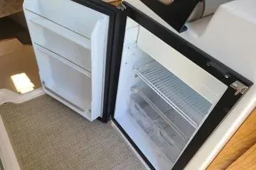  Yacht Photos Pics 2023 Cutwater C-248 Coupe interior fridge with open door, showcasing shelves and storage.