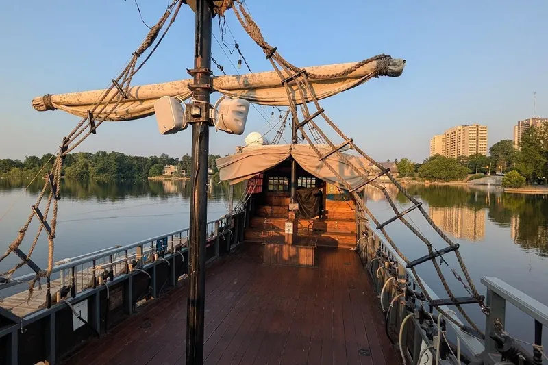  Yacht Photos Pics Custom 2016 pirate ship on calm river, surrounded by trees and buildings.