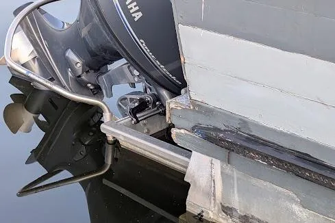  Yacht Photos Pics Outboard motor on a 2016 custom pirate ship, reflecting in calm water.