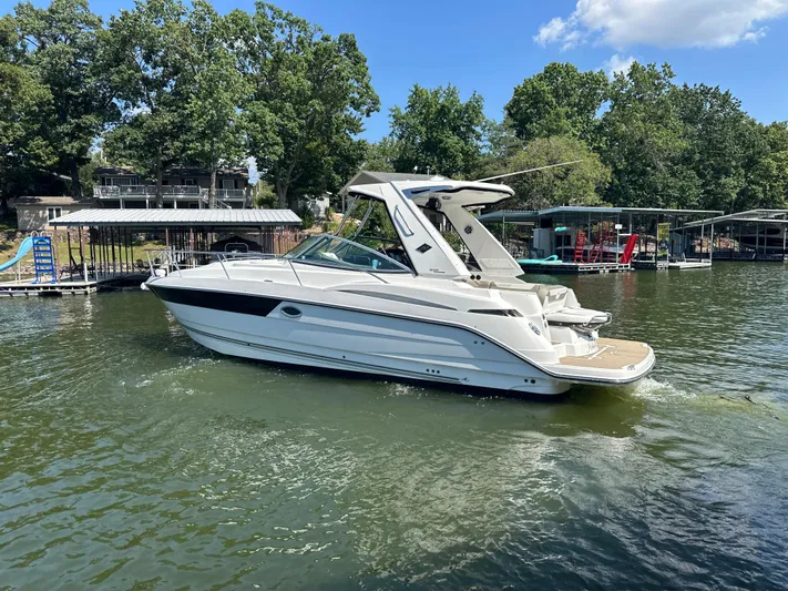  Yacht Photos Pics 2017 Monterey 355 Sport Yacht cruising on a lake near docks and trees.