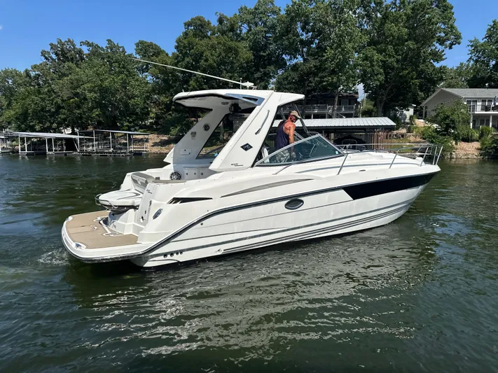 Yacht Photos Pics 2017 Monterey 355 Sport Yacht cruising on a lake with lush green trees.