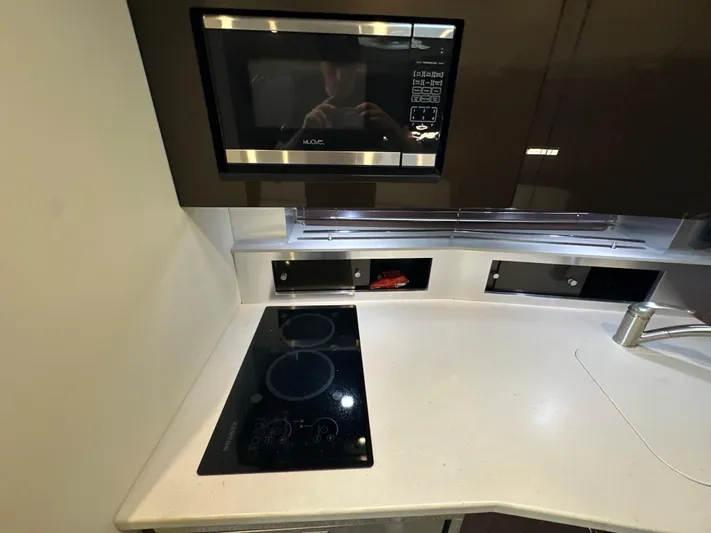  Yacht Photos Pics Modern kitchen area in 2017 Monterey 355 Sport Yacht with stove and microwave.