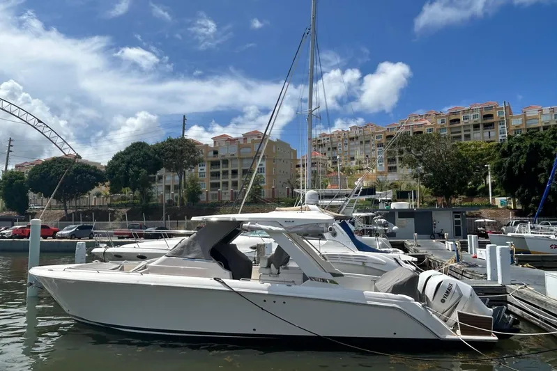  Yacht Photos Pics 2021 Tiara Yachts 34 LS docked at marina, clear sky, waterfront buildings.