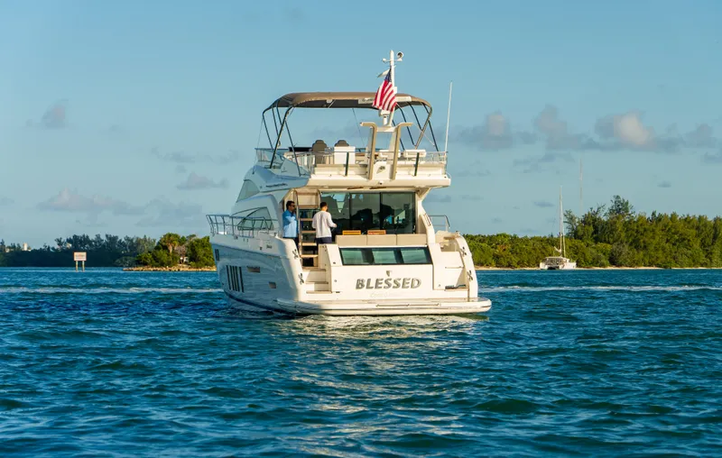 Blessed Yacht Photos Pics 2015 Fairline Squadron 65 yacht cruising on a sunny day with an American flag.