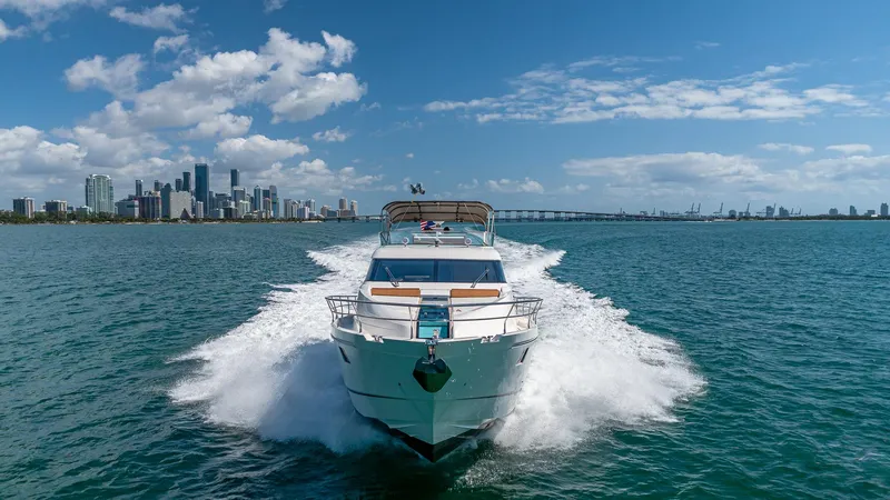 Blessed Yacht Photos Pics Fairline Squadron 65 yacht cruising near city skyline, 2015 model, under clear blue sky.