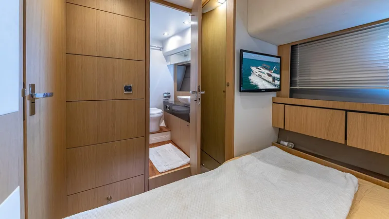 Blessed Yacht Photos Pics Luxurious Fairline Squadron 65 yacht bedroom interior, featuring modern wood finishes and en-suite bathroom.