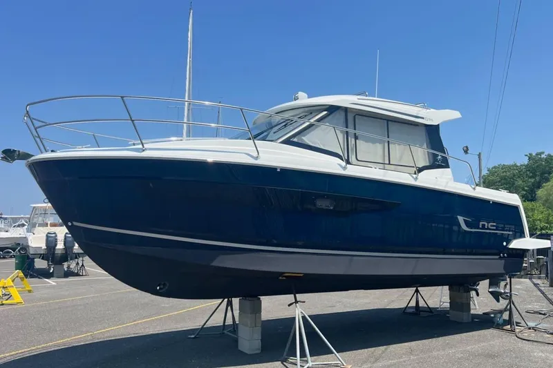 Pisces Yacht Photos Pics 2021 Jeanneau NC 895 boat on stands, blue hull, sunny day, marina background.