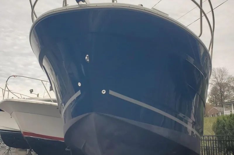 Pisces Yacht Photos Pics 2021 Jeanneau NC 895 boat with blue hull, docked outdoors.