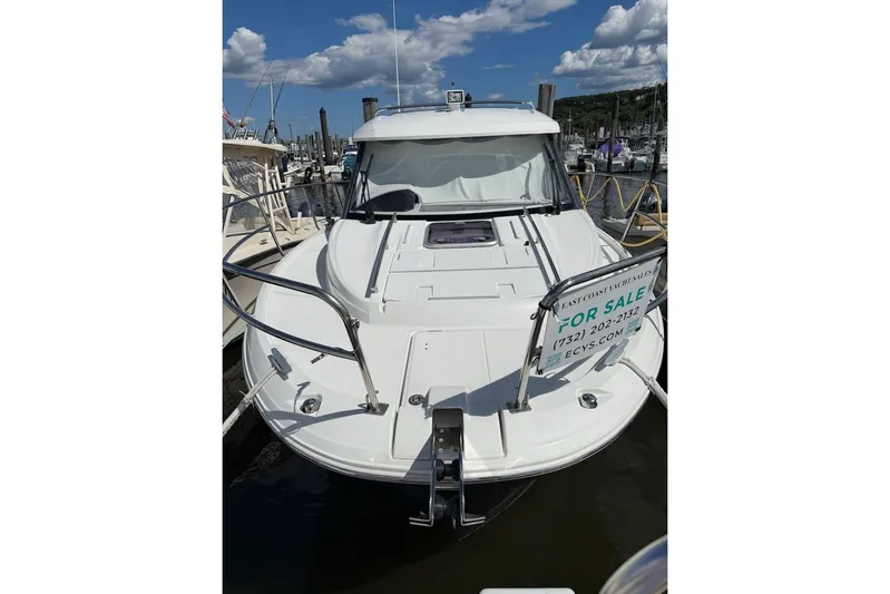 Pisces Yacht Photos Pics 2021 Jeanneau NC 895 boat for sale at marina, clear sky background.