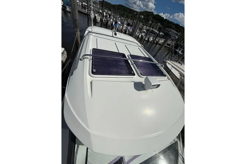 Pisces Yacht Photos Pics 2021 Jeanneau NC 895 boat with solar panels on deck, docked at marina.