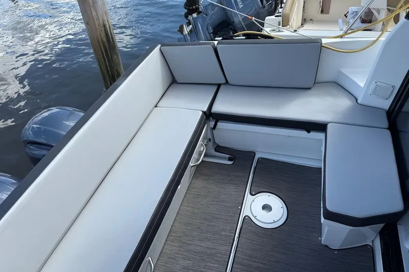 Pisces Yacht Photos Pics 2021 Jeanneau NC 895 boat interior with cushioned seating and deck view.