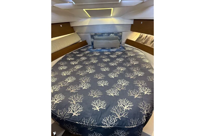Pisces Yacht Photos Pics Luxurious cabin interior of 2021 Jeanneau NC 895 with coral-patterned bedding.