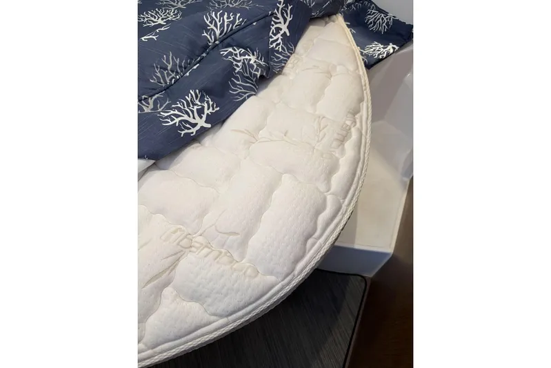 Pisces Yacht Photos Pics 2021 Jeanneau NC 895 boat mattress with blue coral-patterned bedding.
