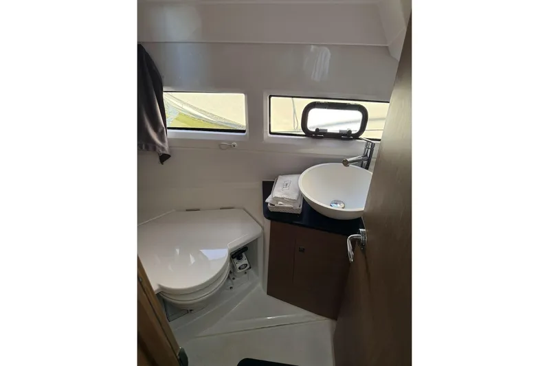 Pisces Yacht Photos Pics 2021 Jeanneau NC 895 boat bathroom with toilet, sink, and window.