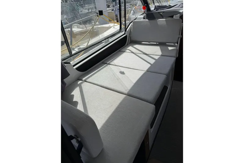 Pisces Yacht Photos Pics 2021 Jeanneau NC 895 interior seating area with light gray cushions.