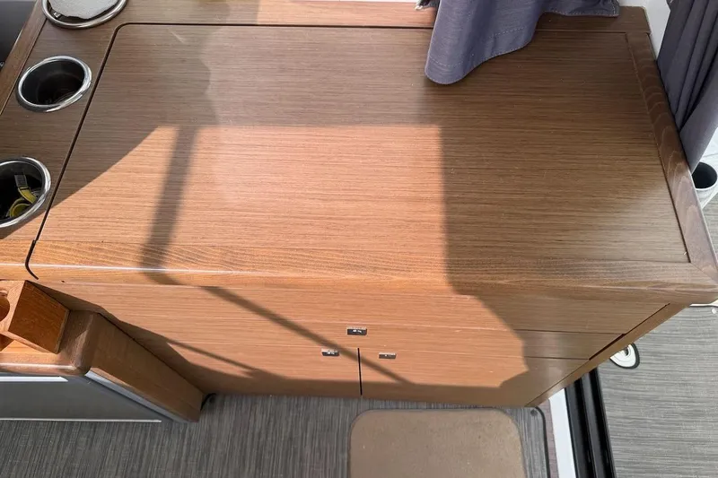 Pisces Yacht Photos Pics Interior view of 2021 Jeanneau NC 895 boat, featuring wooden cabinetry and cup holders.