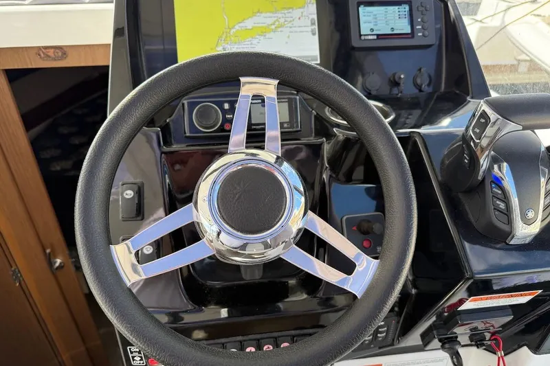 Pisces Yacht Photos Pics Steering wheel and controls of a 2021 Jeanneau NC 895 boat cockpit.