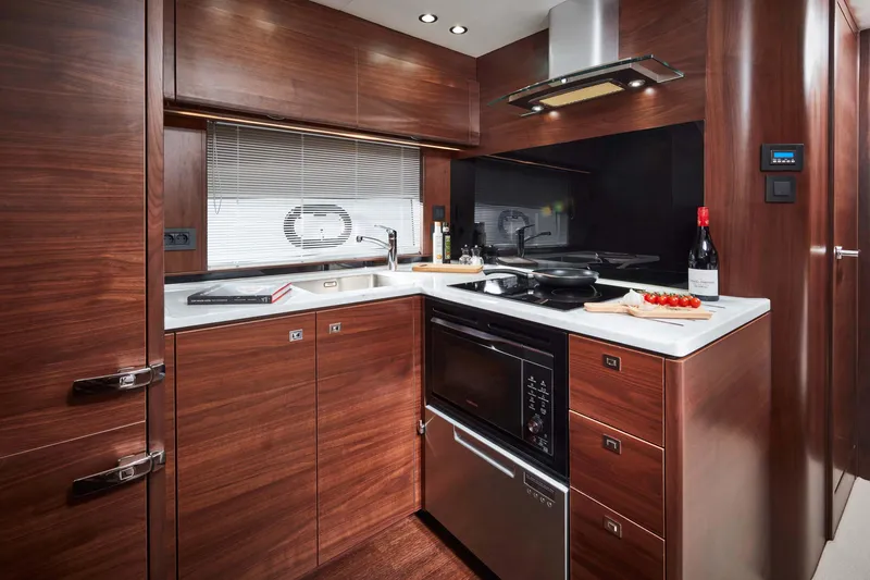  Yacht Photos Pics Luxurious kitchen interior of 2025 Princess V50 Open yacht, featuring modern appliances and wood cabinetry.