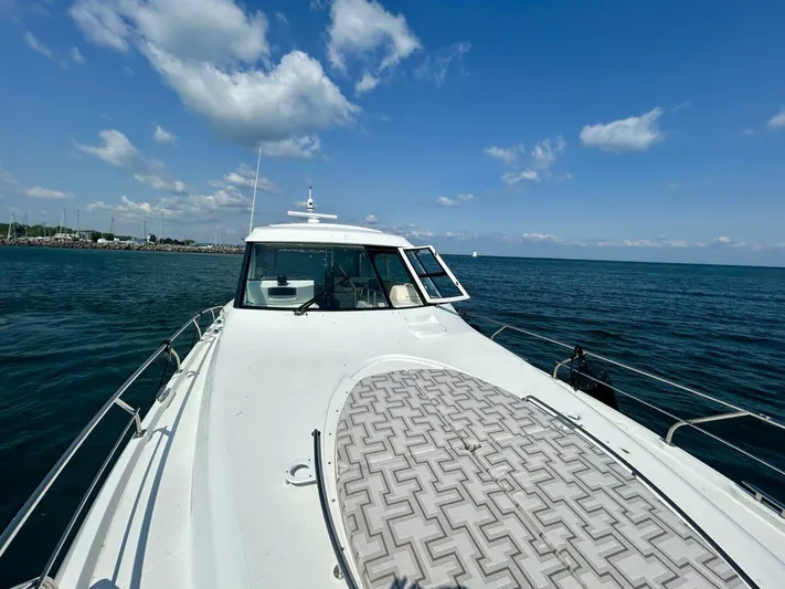  Yacht Photos Pics 2011 Cruisers Yachts 48 Cantius on open water under a clear blue sky.
