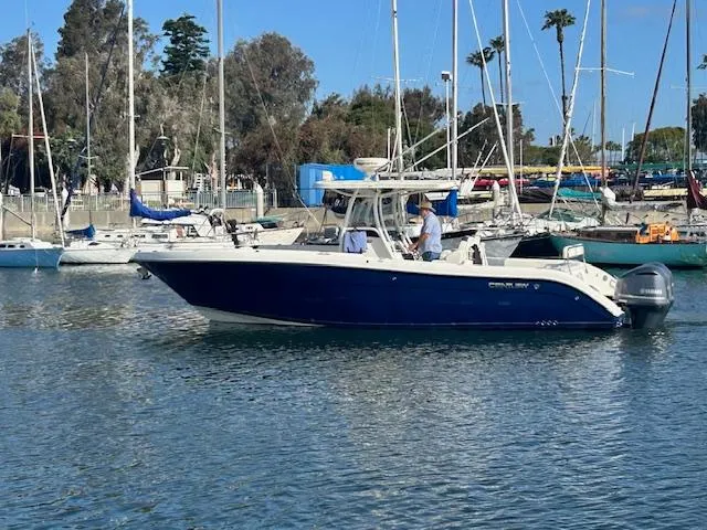 Dolce Vita Yacht Photos Pics 2016 Century 3200 Center Console boat on water, surrounded by sailboats and trees.