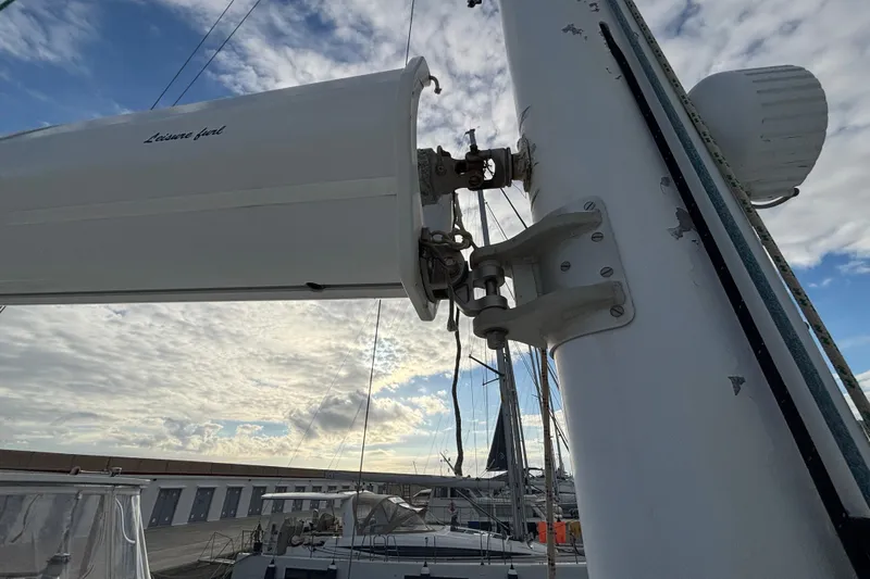  Yacht Photos Pics Sailboat mast and boom connection on 2009 Kelsall 58 KSS, with cloudy sky background.