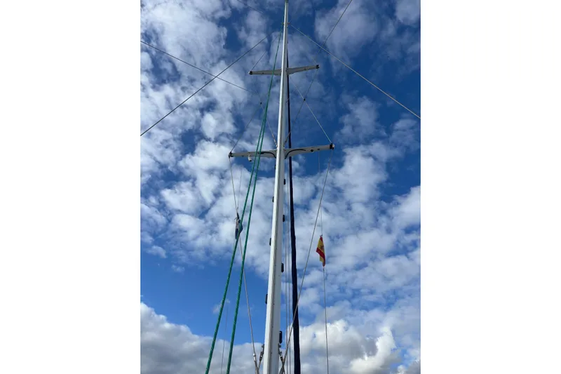  Yacht Photos Pics Mast of 2009 Kelsall 58 KSS sailboat against a cloudy blue sky.