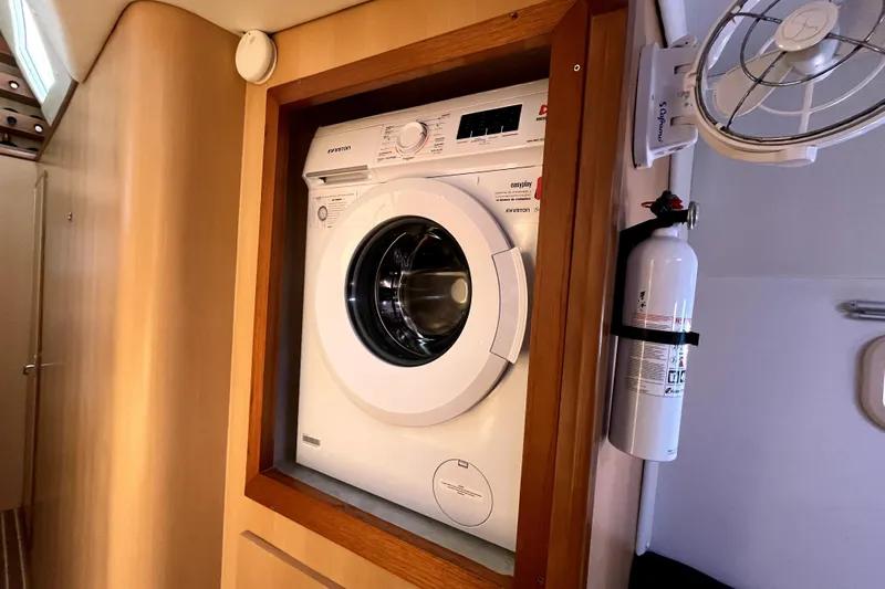  Yacht Photos Pics Washing machine in a 2009 Kelsall 58 KSS yacht interior, with fire extinguisher and fan.