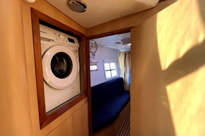  Yacht Photos Pics Interior of 2009 Kelsall 58 KSS yacht with washing machine and seating area.