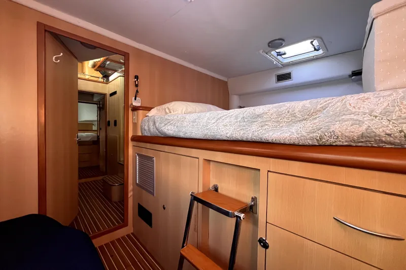  Yacht Photos Pics Interior cabin of 2009 Kelsall 58 KSS yacht with wooden finish and cozy bedding.