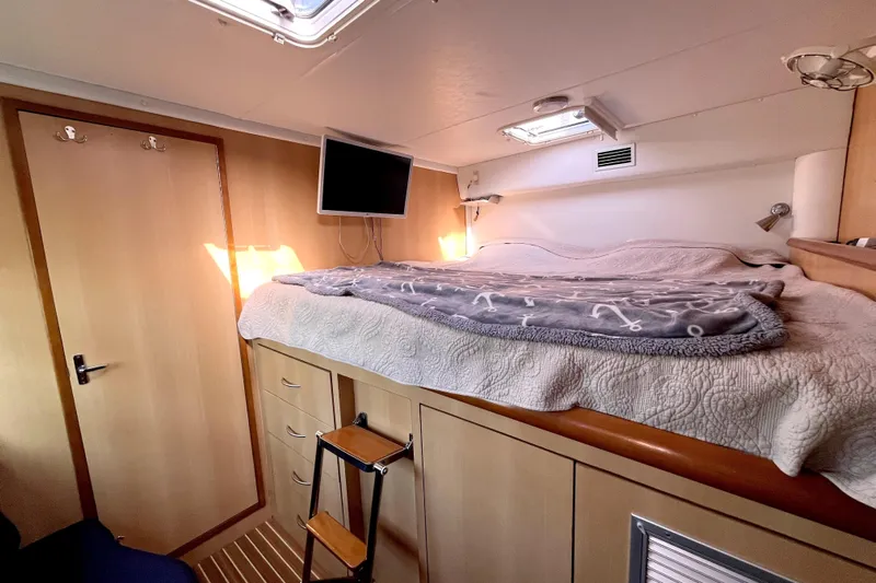  Yacht Photos Pics Cozy cabin interior of 2009 Kelsall 58 KSS yacht with bed, TV, and storage.