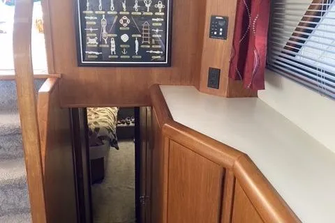 Gloryb2god Yacht Photos Pics Interior of a 1990 Carver 55 yacht, featuring wooden cabinetry and a framed nautical knot display.